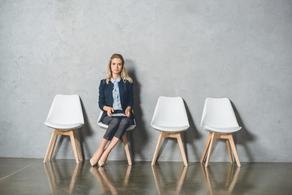 Good business strategy - woman sat alone on a queue of chairs - Julia ngapo Business Coaching