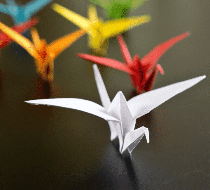 Demonstrate Leadership origami birds against black background